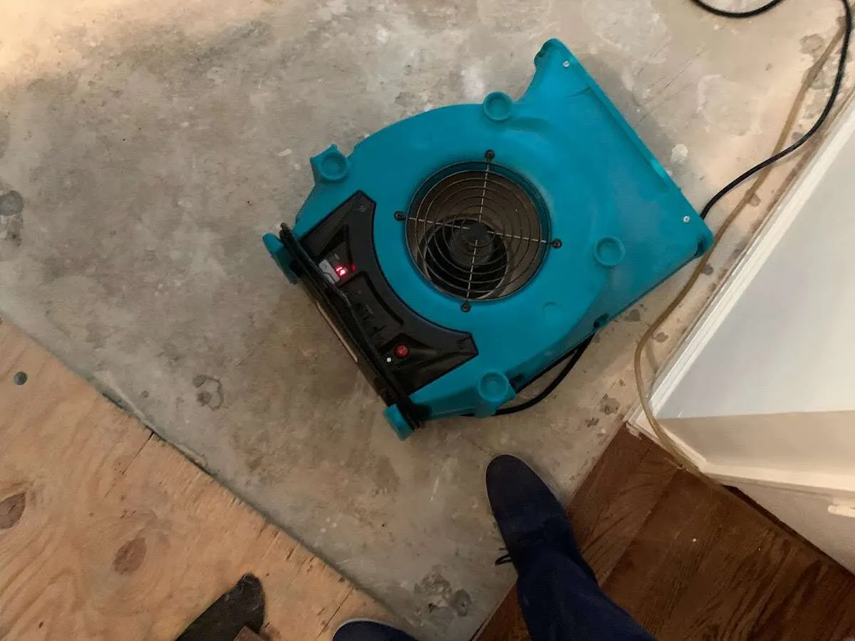 Air mover drying subfloor during Commercial Water Damage Restoration in Howard